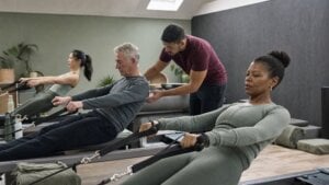 Pilates instructor adjusting a client during a reformer class