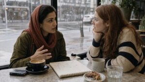 Two women entrepreneurs talking at a cafe table on a rainy day