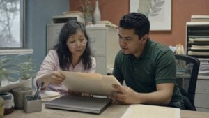 Practice manager and staff member reviewing files in a back office
