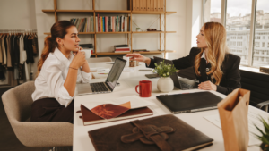 Woman entrepreneur and creative agency director having a strategy meeting over coffee in a bright studio